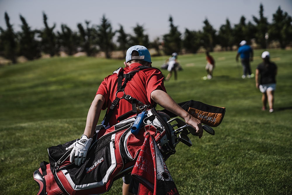 a golfer carrying a large golf bag