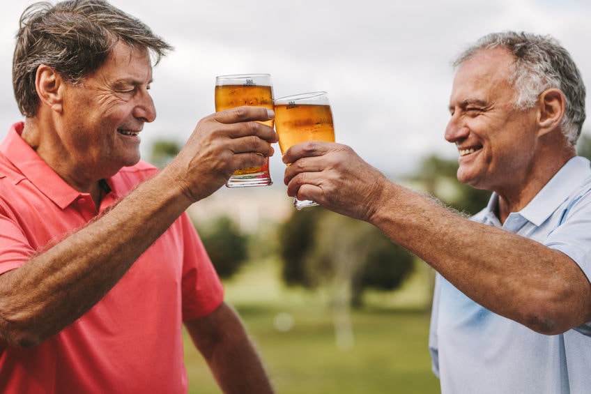 two older golfers having a beer after playing