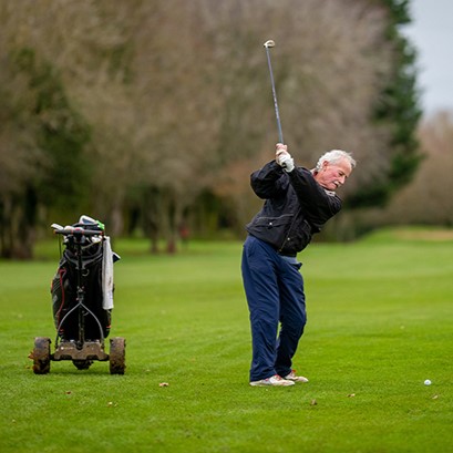golfer with an electric trolley on fairway